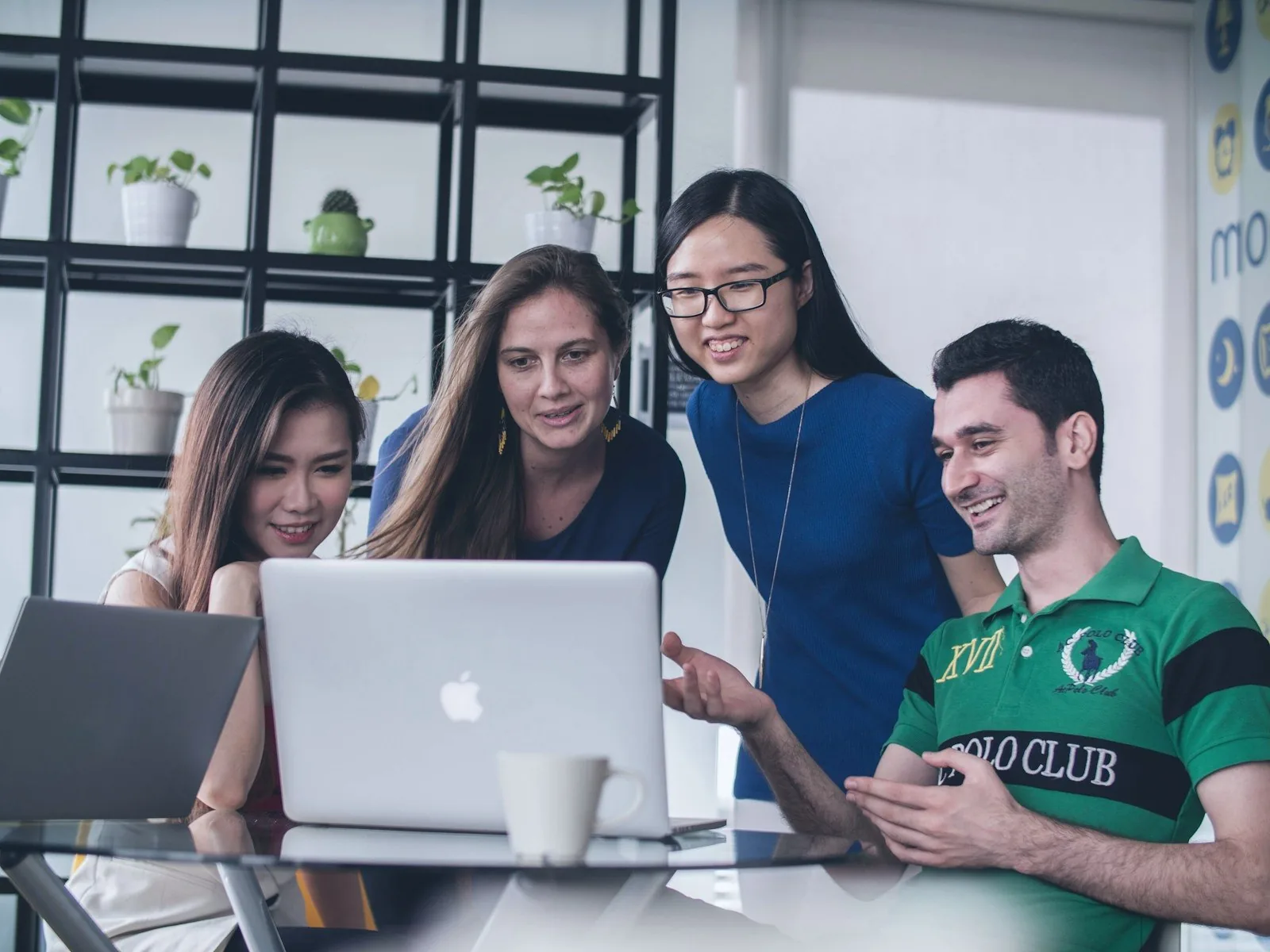 Team collaborating around a laptop
